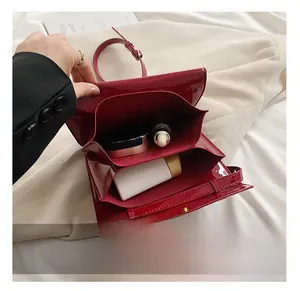 Detail showing red oil wax leather envelope bag with three functional inner compartments