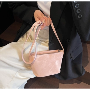 Détail du sac seau rose embossé avec motifs 3D de cœurs et d'ours sur le cuir