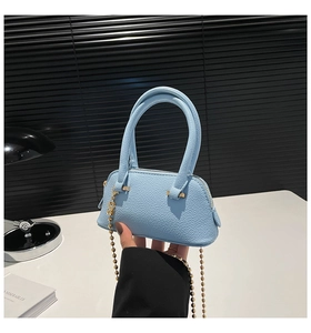 Close-up of light blue lychee pattern shell bag with golden bead chain detail