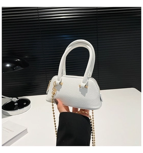 Detail view of white lychee texture mini bag with golden ball chain strap and top handle