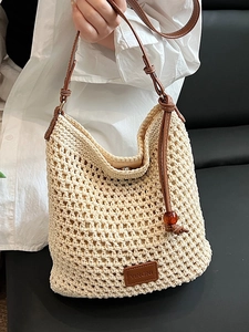 Chic beige woven tote bag with brown leather straps and stylish amber ball charms