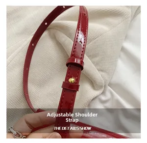 Detail of red wax leather adjustable shoulder strap with gold mushroom stud buckle