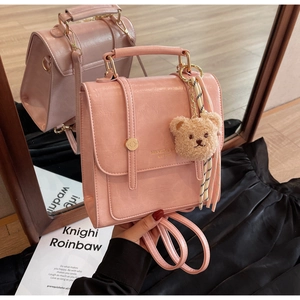 Pink faux leather backpack featuring a cute bear plush pendant and striped silk scarf detail