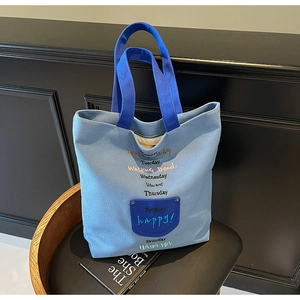 Close-up of color-block canvas tote bag with detailed colorful letter embroidery