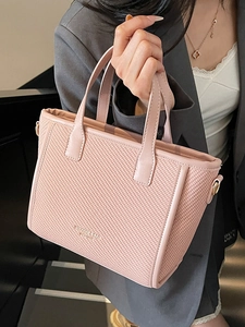 Pink woven bucket bag with gold lettering and leather trim for women's crossbody wear