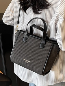 Elegant black woven tote bag with top handle and slim crossbody strap for women