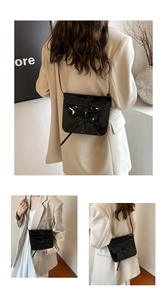 Detail of black patent leather ballet style crossbody bag with a delicate bow accent