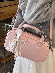 Sac Boston en cuir rose avec nœuds en dentelle, perles et ruban à carreaux sur l'anse