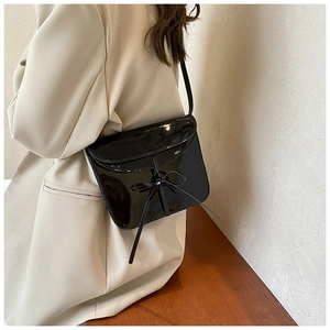 Glossy black oil wax leather crossbody bag featuring a chic bow and envelope flap design
