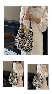 Detail of hand-knitted granny square tote bag with black and white crochet floral patterns