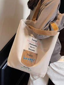 Beige canvas tote bag with embroidered letters and brown wide straps for daily use