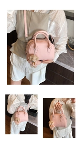 Pink pebbled leather Boston bag detail featuring a cute teddy bear charm and strap
