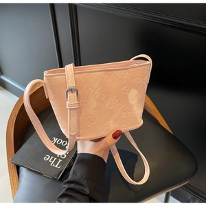 Détail du sac seau rose clair avec gaufrage de papillons et fleurs et fermeture éclair métal
