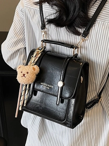 Black glossy leather square backpack with top handle and a cute brown plush bear charm