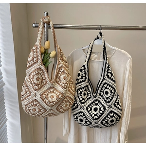 Close-up of handmade crochet pattern on a bohemian tote bag in neutral colors