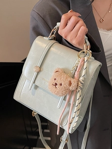 Minimalist light green leather crossbody bag with teddy bear charm and gold buckle
