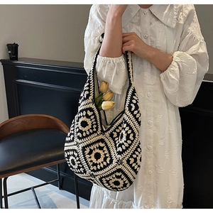 Detail of bohemian crochet tote bag showing black and white grandmother square pattern