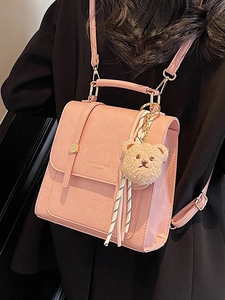 Pink minimalist PU leather backpack and handbag with cute plush bear charm on model