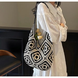 Detailed close-up of handmade black and white crochet tote bag with geometric pattern