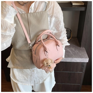 Pink lychee grain bowling handbag with cute bear charm shown in a cozy lifestyle setting