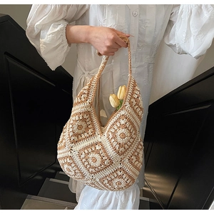 Detail of hand-woven crochet hobo tote bag featuring retro floral sun pattern stitch