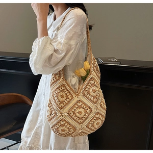Close-up of bohemian crochet tote bag with brown flower patterns and woven strap