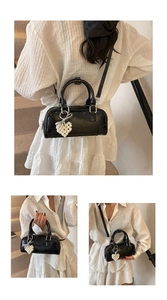 Detail of black glossy bowling bag with decorative white pearl heart charm and strap