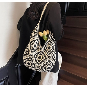 Close-up of handmade crochet tote bag with black and white floral geometric patterns