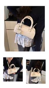 Close-up of cream Boston bag with pearl heart charm and silver bow detail for women