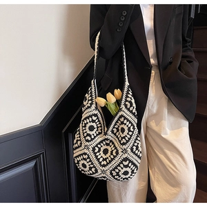 Close-up of black and white crochet tote bag featuring geometric floral patterns