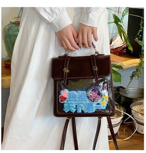 Brown vintage faux leather ita bag with clear window showing anime badges and inserts