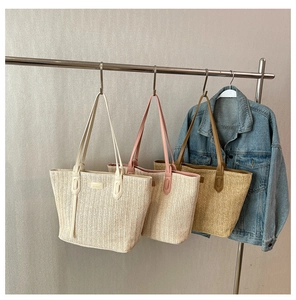Detailed woven texture of large straw tote bags in beige, pink, and light brown colors