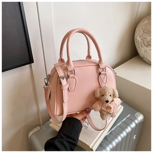 Pink lychee textured faux leather bowling bag with cute teddy bear charm and logo detail