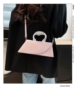 Détail du sac à main en cuir rose avec une poignée unique en métal liquide argenté