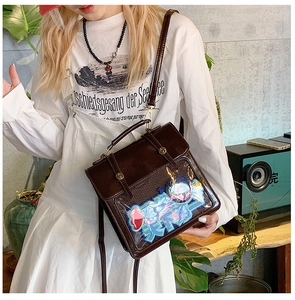Close-up of brown vintage PU leather ita-bag with transparent window and decorative art