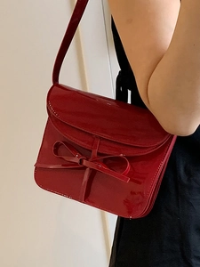 Glossy red oil wax leather ballet style crossbody bag with decorative bow detail