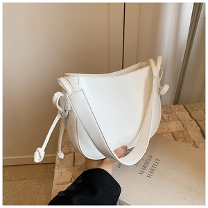 Dettaglio della borsa hobo bianca minimalista con nodo decorativo sulla tracolla