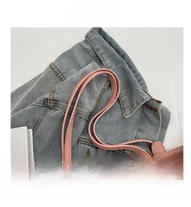 Detailed macro view of pink PU leather shoulder straps and beige woven bag texture