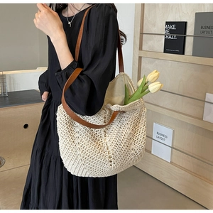 Detail of hand-woven cream tote bag featuring brown leather straps and large capacity design