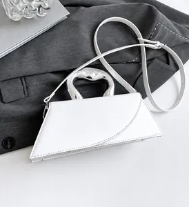 Detailansicht der weißen Trapez-Tasche mit silbernem Metallgriff und glatter Oberfläche