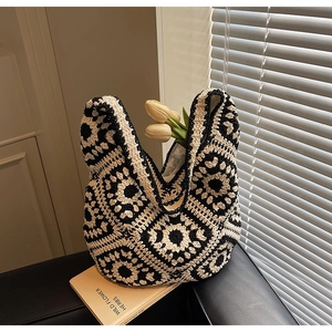 Detailed close-up of handmade crochet sunflower patterns on a knit cotton tote bag