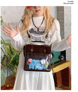 Close-up of brown vintage itabag showing transparent window with heart-shaped decorations