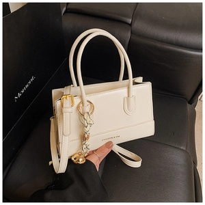 Detail der weißen PU-Ledertasche mit Seidentuch-Anhänger und goldfarbenen Metallbeschlägen