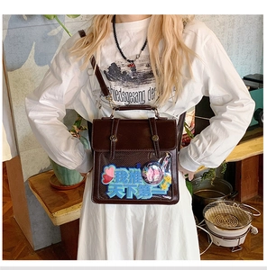 Detail view of deep brown leather itabag featuring a transparent PVC display window