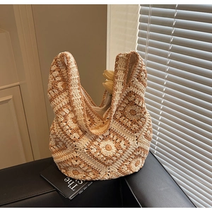 Detailed close-up of bohemian crochet knit tote bag with floral patterns and soft texture