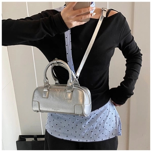 Detail of silver metallic handbag with crinkle texture and ROAD & MOX logo branding