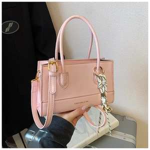 Rosafarbene quadratische Handtasche aus Kunstleder mit Goldanhänger und gewebtem Seildetail