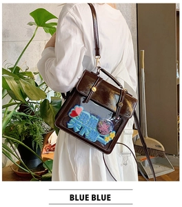 Detail of dark brown faux leather ita bag with transparent window and anime badges