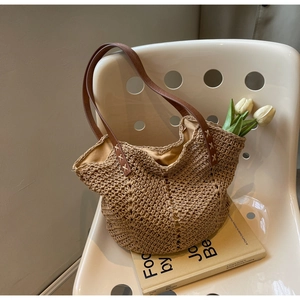 Close-up of handwoven tote bag featuring brown leather straps on a vintage chair