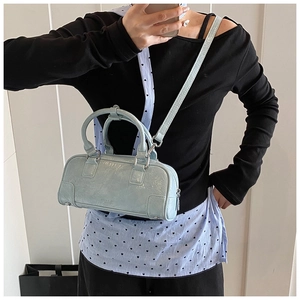Detail showing mint blue crinkled patent leather Boston bag with round top handles and strap